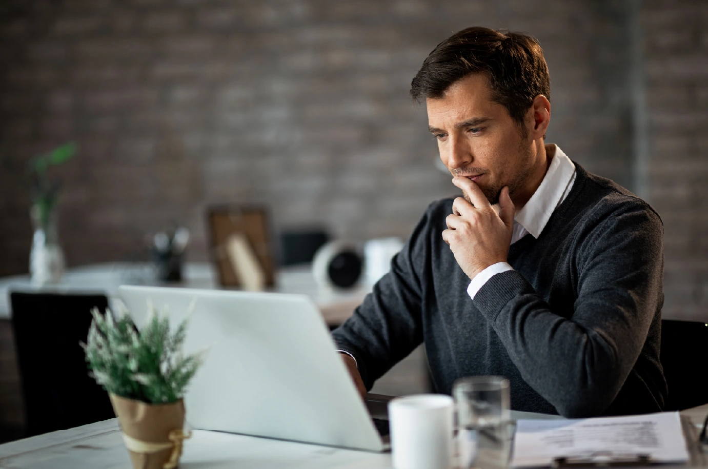 Profesional reflexivo frente a laptop, cómo expandir tu marca personal según tu industria